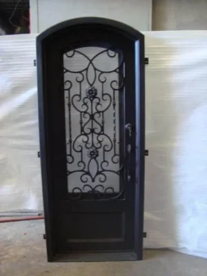 Single arched wrought iron door EL1080 MCD with scroll centerpiece and glass, handcrafted for strength and elegance.