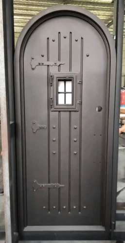 Rustic wrought iron door EL1010 with solid panel, rivets, and small square window, handcrafted for strength and charm.