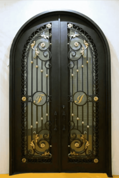 Ornate arched wrought iron door EL1163 MCD with scrollwork, rosettes, and embossed panels, hand-forged for secure artistry.